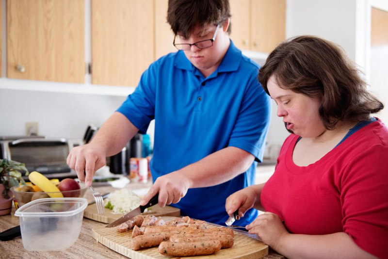 Two people with developmental disabilities planning their meals in the kitchen