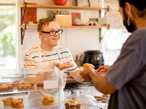 Man with a disability behind the counter of a bakery