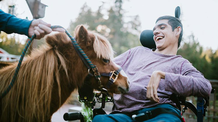 Man with a developmental disability petting a horse
