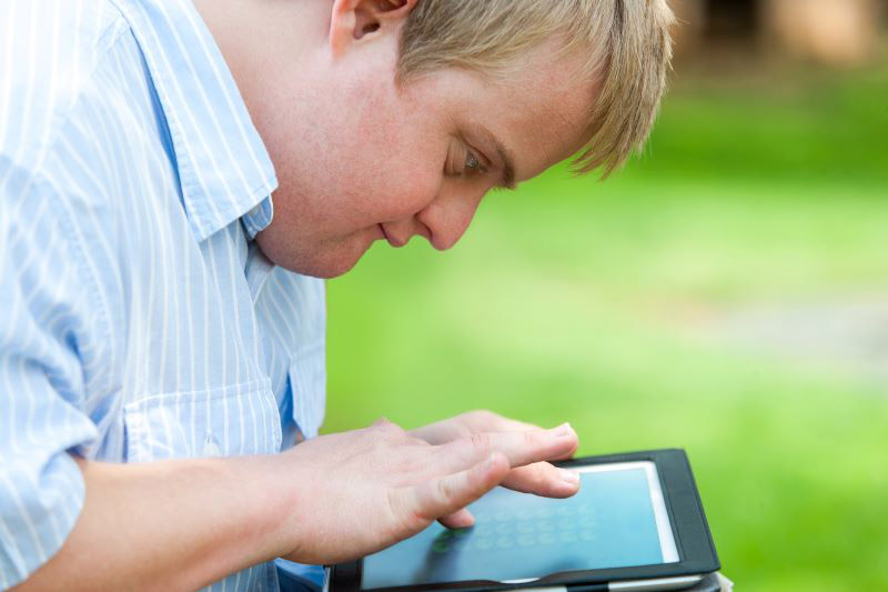 Man with a developmental disability looking at a home automation tablet