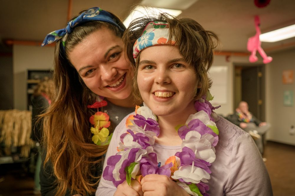 A female Direct Support Professional hugging a woman with a disability