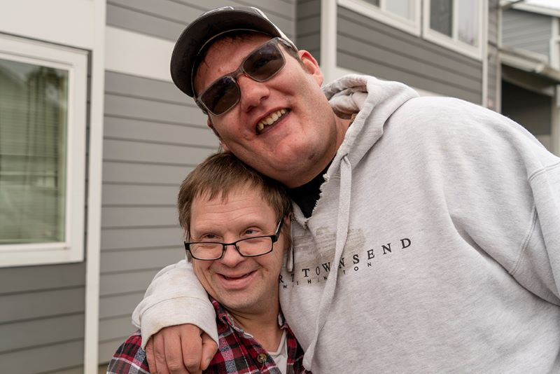Jordan, a person AbleLight supports through Supported Living Services, smiling outside of his apartment