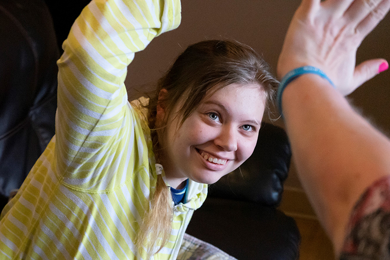 Two women in an AbleLight Group Home high-fiving each other