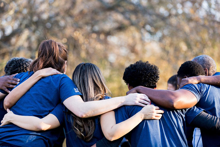 A diverse group of people huddling