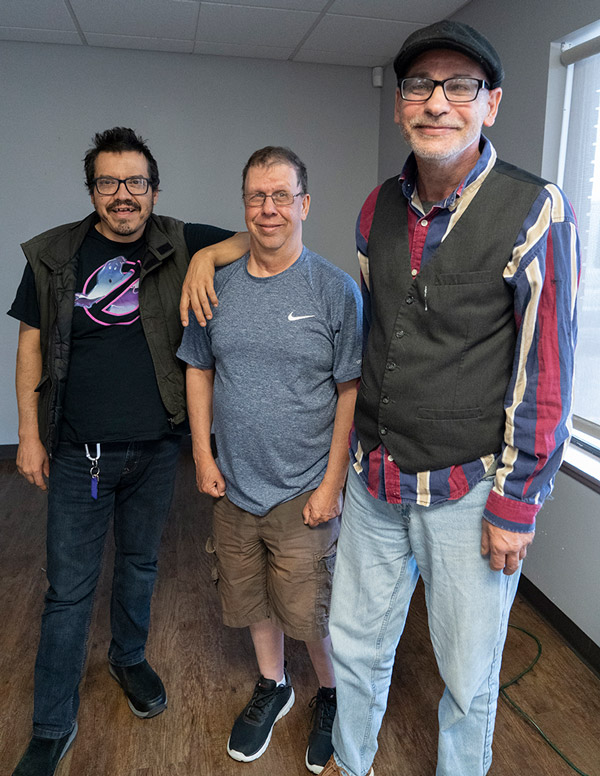 Three men with developmental disabilities posing