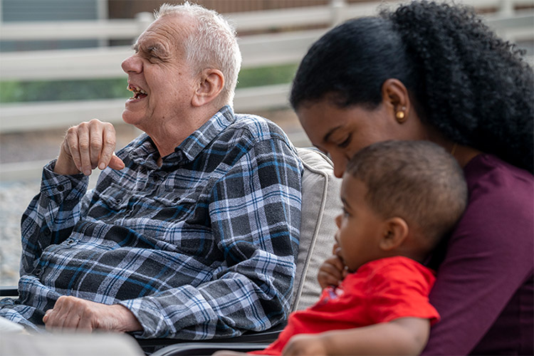 Older man with IDD smiling with his host home family