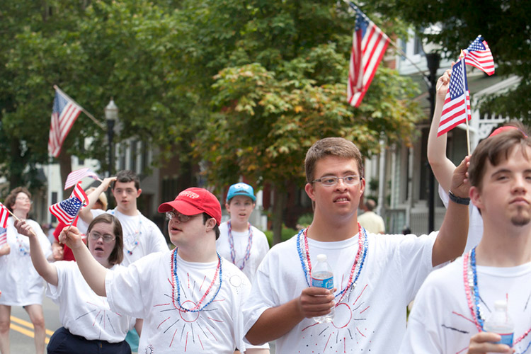 Group of people with developmental disabilities marching in a parade for Independence Day