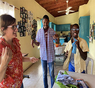 Deaconess Danelle Putnam-Schumann with Junior and Moises trying on new shirts