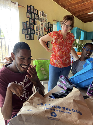 Deaconess Danelle and Moises rejoicing with Junior over his new tennis shoes