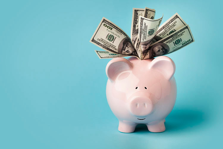 Pink piggy bank stuffed with $100 bills