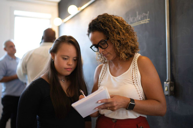 A job coach assisting a young woman with a developmental disability