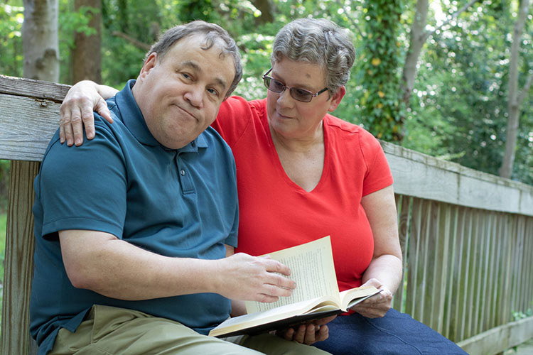 Man with caregiver reading a book