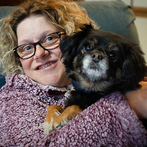 Candice holding a small, black dog