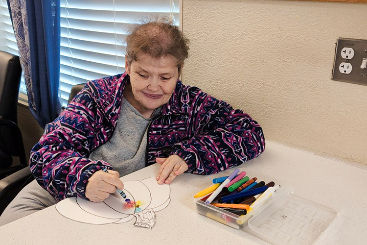 Claudia drawing in an AbleLight Congregate Living home