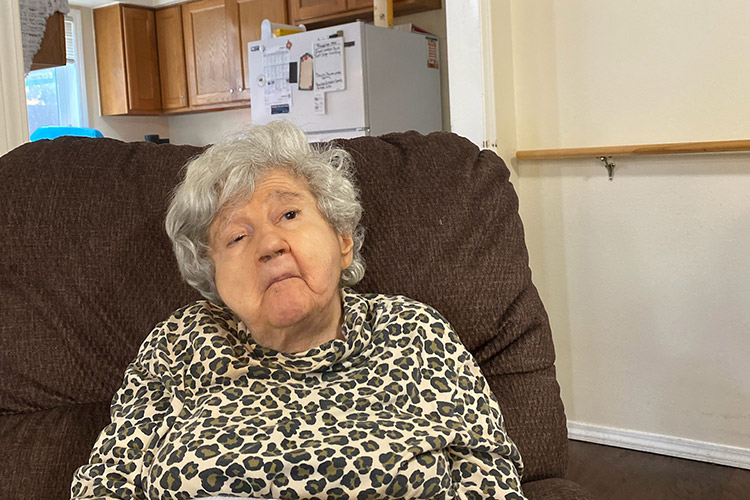 An older woman with a developmental disability sitting in a chair in an AbleLight home