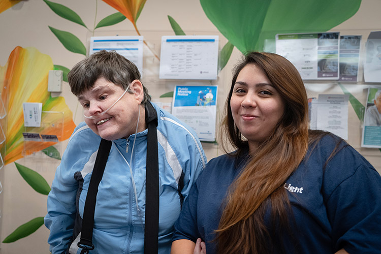 A female AbleLight employee smiling with a woman that has a developmental disability