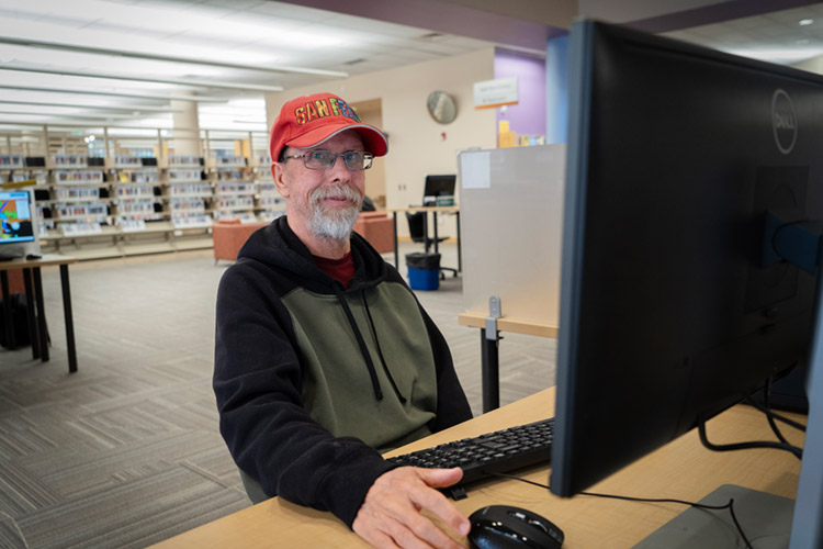 Randall, a man with a developmental disability, at the computer in a library