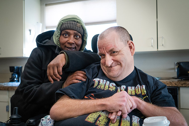 Woman with a developmental disability smiling with a man in a wheelchair