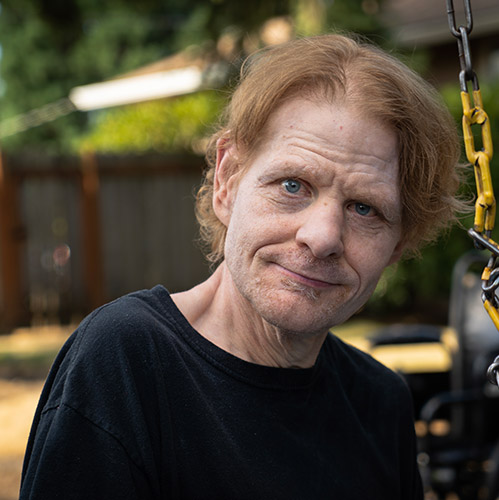 Man with a developmental disability by a park swing