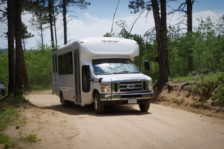 An AbleLight transportation van driving on the road