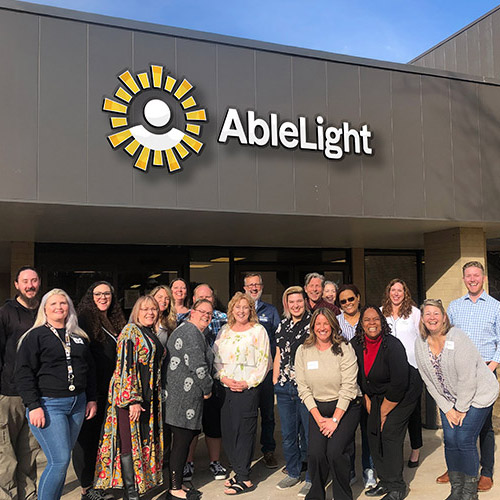 AbleLight team members outside of an AbleLight building