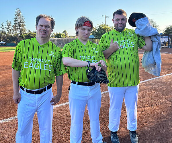 Three men in green softball uniforms