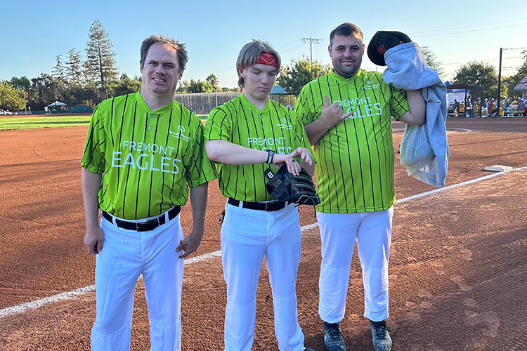 Three men in green softball uniforms