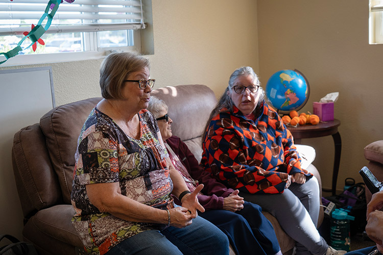 A staff member talking with two female participants at AbleLight's Colorado Springs Day Program