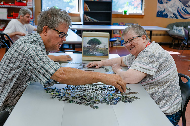 Two people with developmental disabilities working on a jigsaw puzzle
