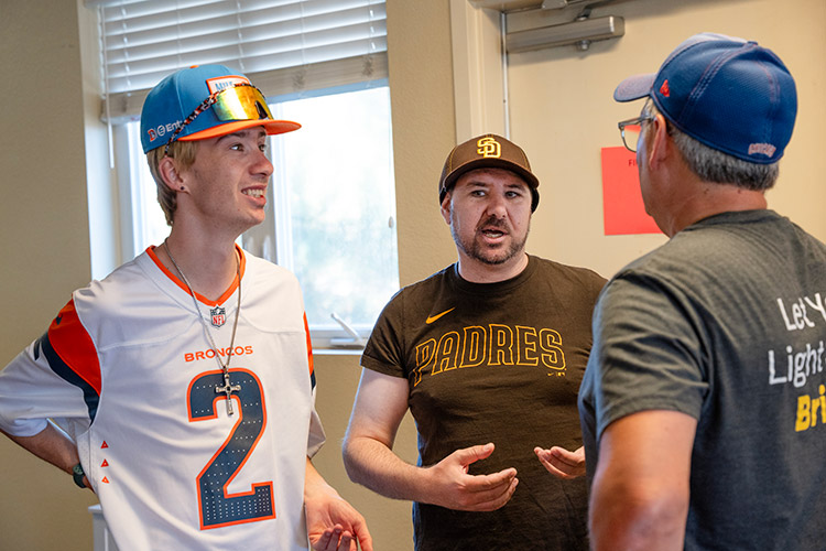 Two participants of AbleLight's Day Program talking to a staff member.