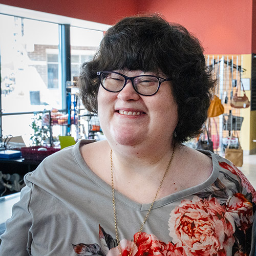 Nicole, an employe at an AbleLight Thrift Shop, smiling on the job