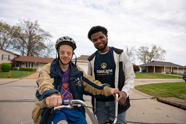 An AbleLight DSP teaching a man with developmental disabilities how to ride a bicycle