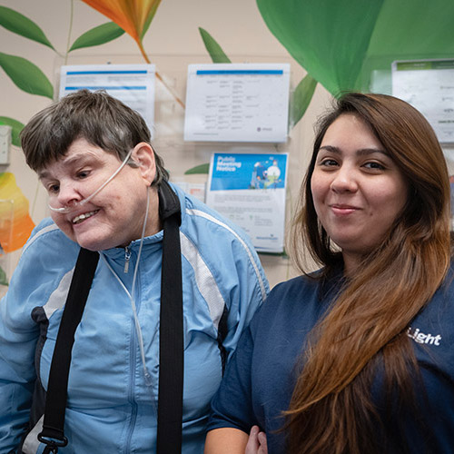 A woman with a developmental disability smiling with an AbleLight staff member