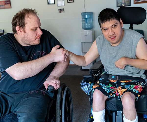 Two friends with developmental disabilities shaking hands
