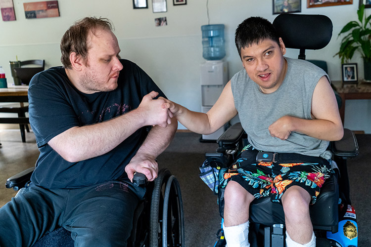 Two friends with developmental disabilities shaking hands