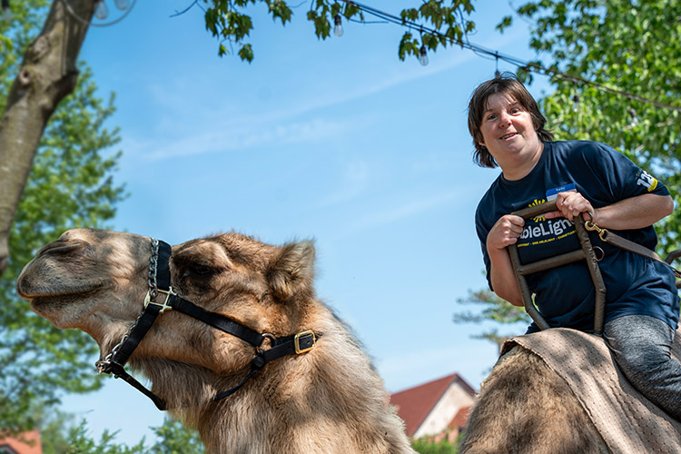 A woman with a developmental disability riding a camel