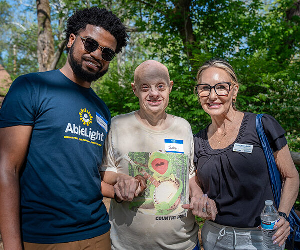 An AbleLight employee, a man with a IDD and an AbleLight Board Member posing