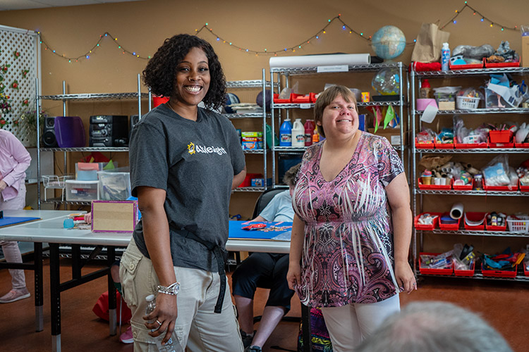 A female AbleLight team member with a participant in AbleLIght's Day Program