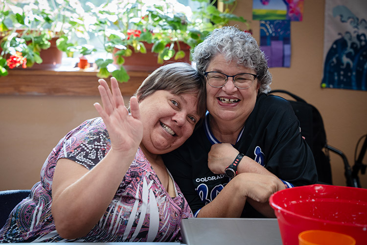 Two women with developmental disabilities smiling