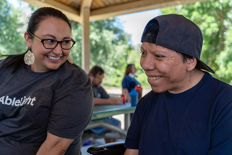 An AbleLight team member with a man with a developmental disability at a park