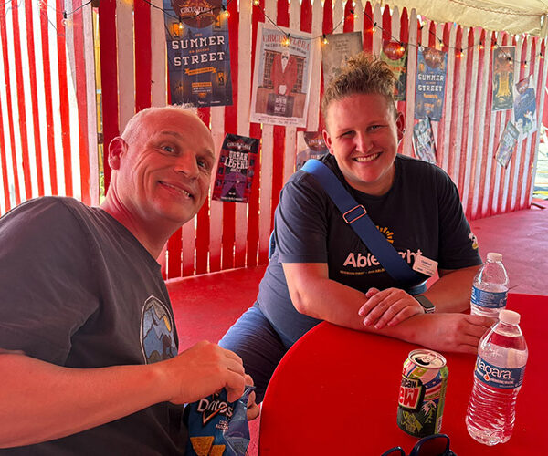 An AbleLight team member and man supported by AbleLight at a sensory-friendly circus