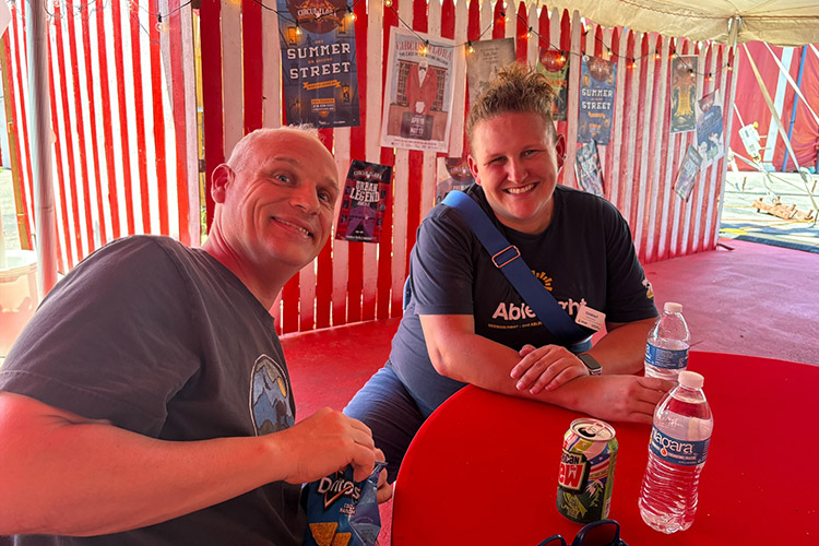 An AbleLight team member and man supported by AbleLight at a sensory-friendly circus