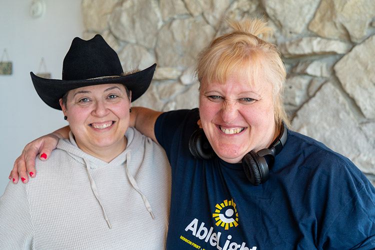 A woman supported by AbleLight and an AbleLight employee