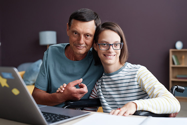 A teenage girl with IDD and her father working at a computer