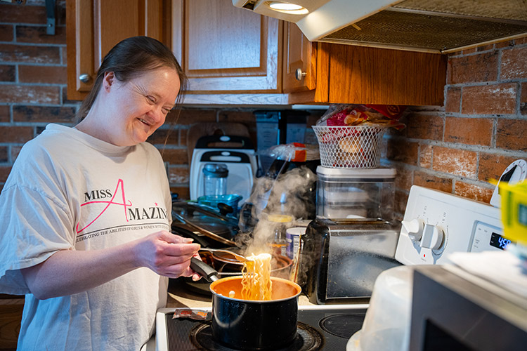 A woman with IDD cooking in her kitchen