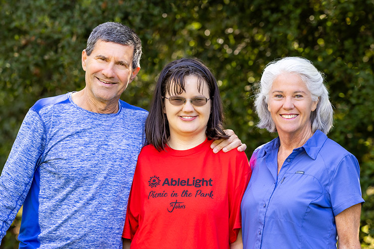 A woman with a disability smiling with her family