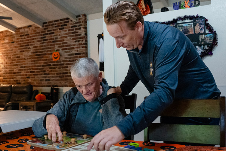 An AbleLight team member with a man supported by AbleLight